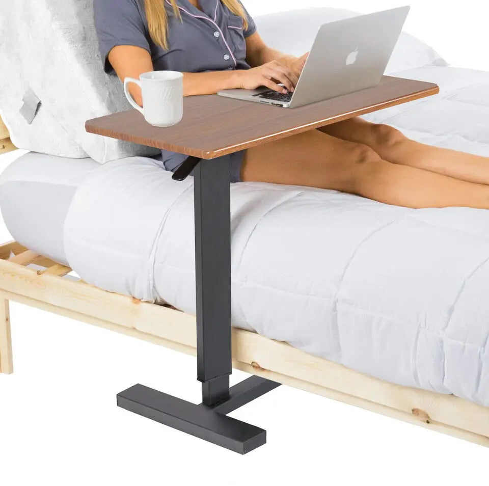 Height-adjustable overbed table on black base, sized for laptop and drinks