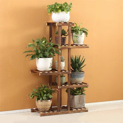 Tall wooden plant stand with five slatted shelves holding multiple potted plants