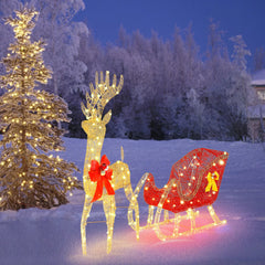 Lit golden reindeer and red sleigh decoration with bow accents and glowing wire lights