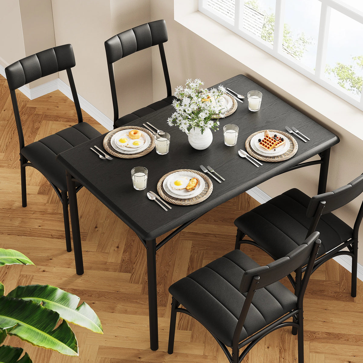 Rectangular dining table with dark tabletop and black upholstered dining chairs