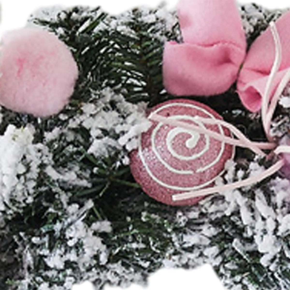 Close-up: frosted pine wreath with pink pom poms and spiral swirl ornament.