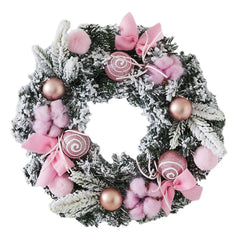 Frosted pine wreath with pink bows, fuzzy pom poms, and rose-gold ball ornaments.