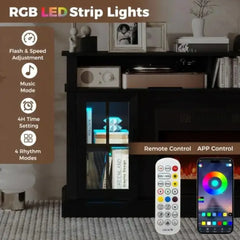 Black TV stand with electric fireplace and RGB LED lighting, remote control shown.