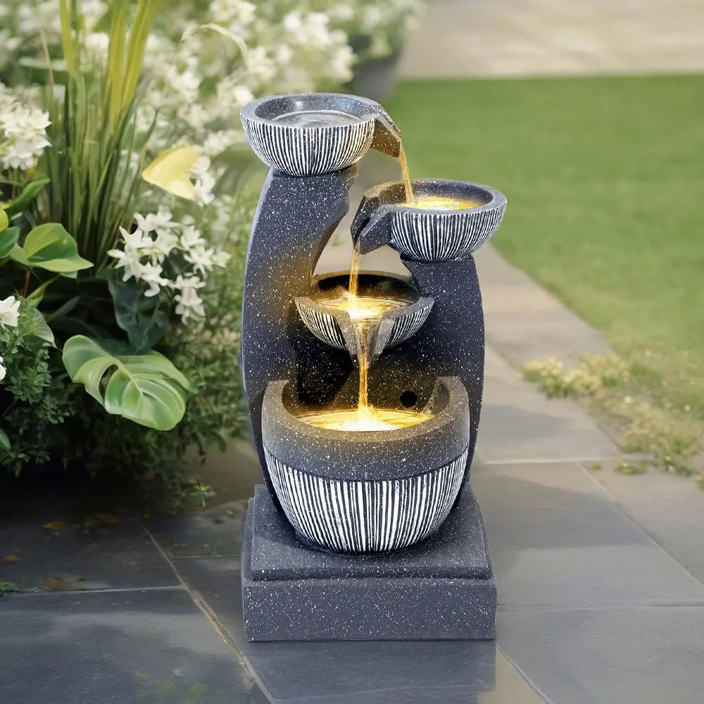 Solar outdoor fountain with tiered gray stone basins, lit water stream, and solar panel