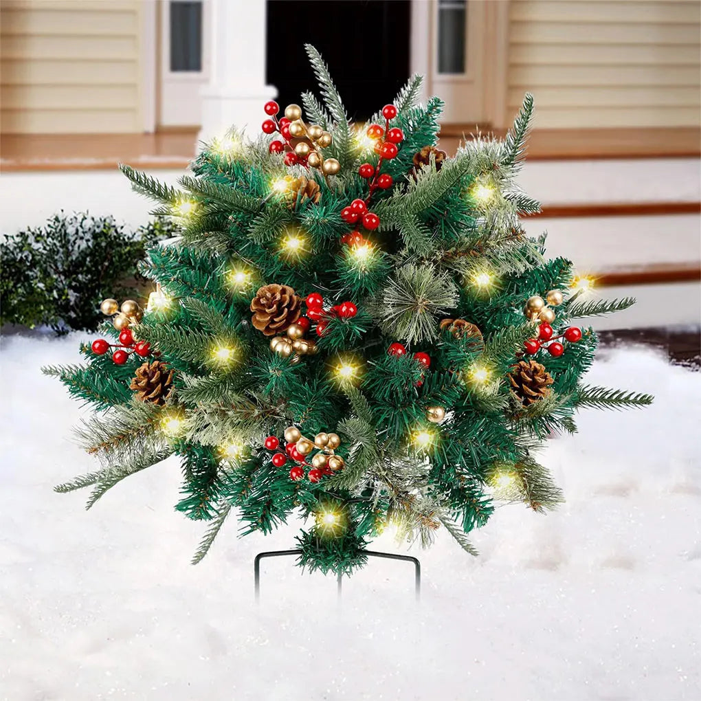 Green outdoor Christmas tree in a decorative urn with warm white lights and red ornaments