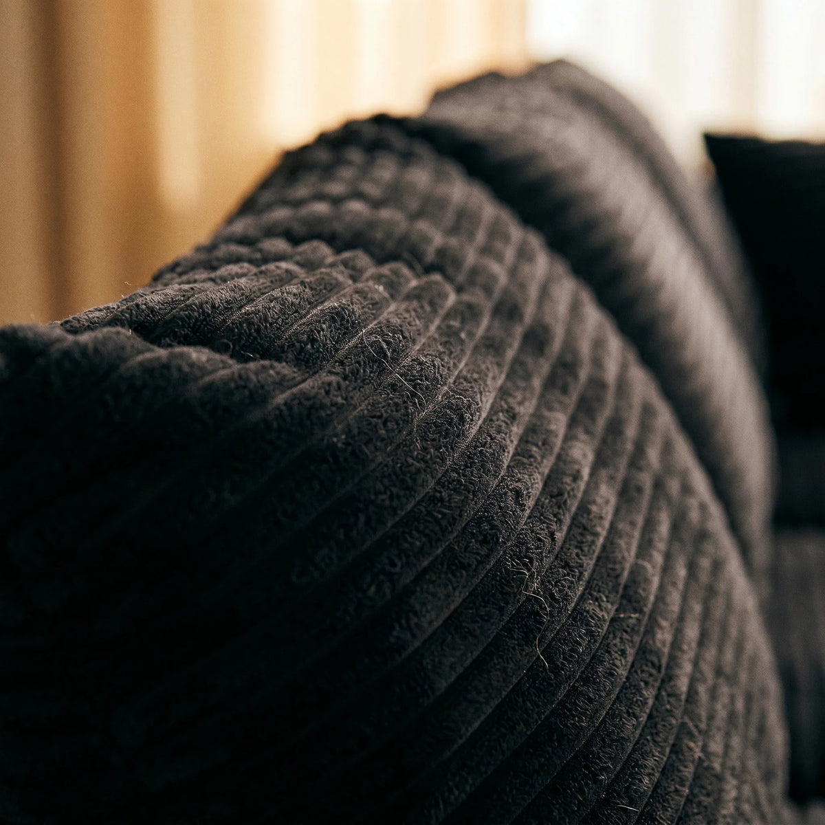 Close-up of black vertical striped corduroy fabric on sofa cushion
