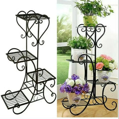 Four-tier black metal plant stand with scrollwork and tiered wire shelves