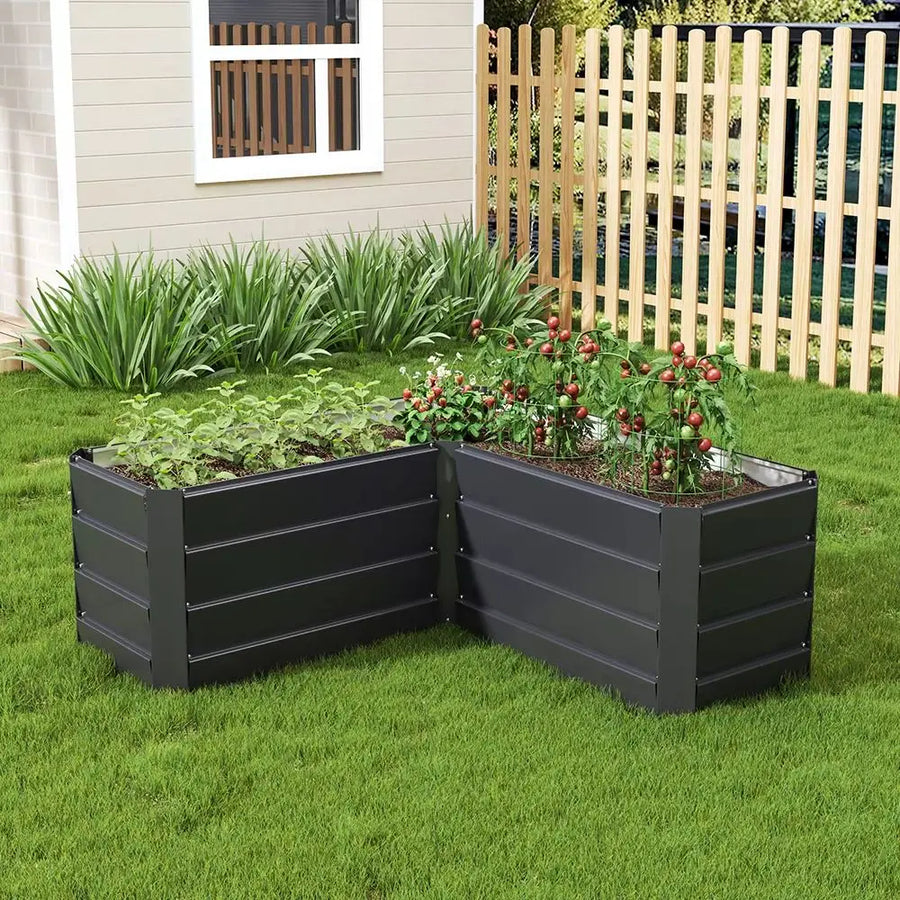 Charcoal black L-shaped metal raised garden bed with raised tiers, filled with plants
