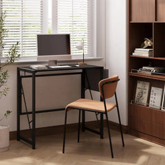Black folding table in a home office with dark tabletop and sturdy legs