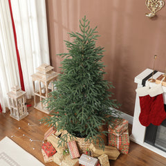 Full spruce Christmas tree, green, with small string lights and wrapped presents at base