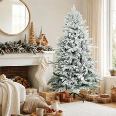 White snow-flocked artificial Christmas tree with dense branches and metal base