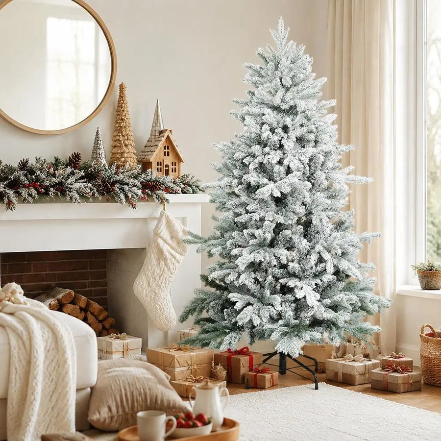 White snow-flocked artificial Christmas tree with dense branches and metal base