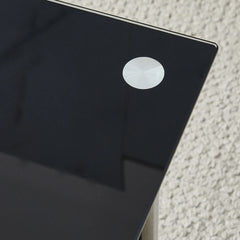 Black glass tabletop corner detail with circular edge cap