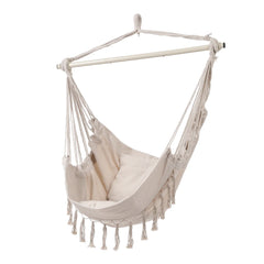 White canvas hanging swing chair with fringe tassels and spreader bar frame.