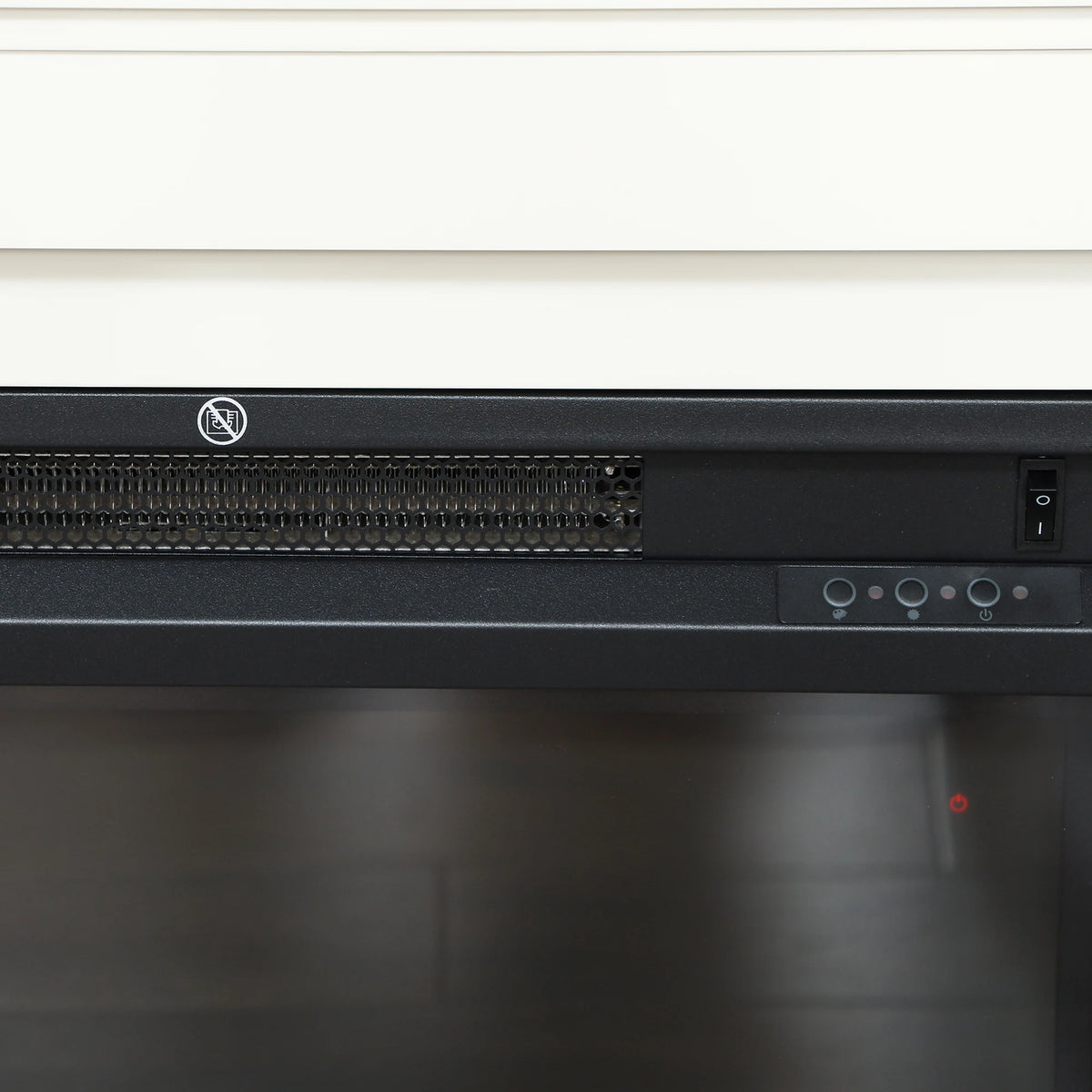 Electric fireplace control panel and vent grille beneath the black firebox screen