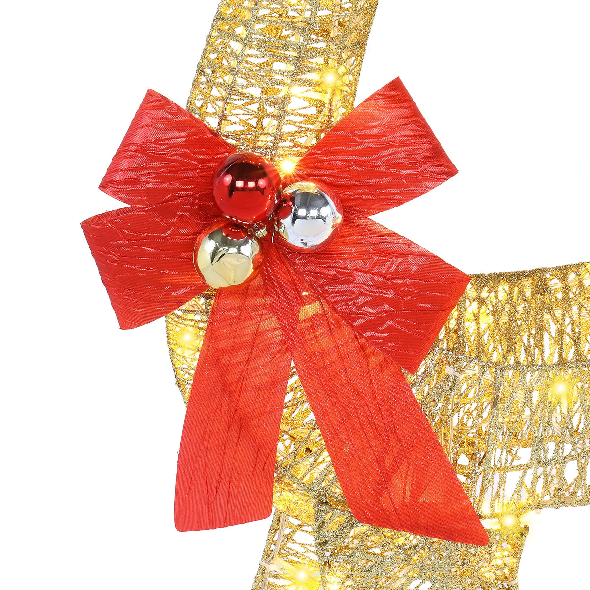 Close-up of golden reindeer ornament with large red bow and glossy bell ornaments