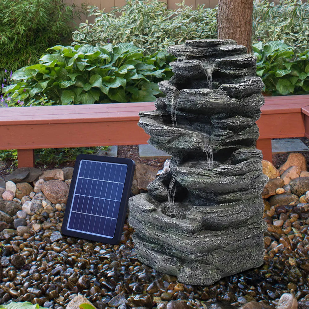 Solar outdoor rockery fountain with black stone tiers, water basin, and solar panel