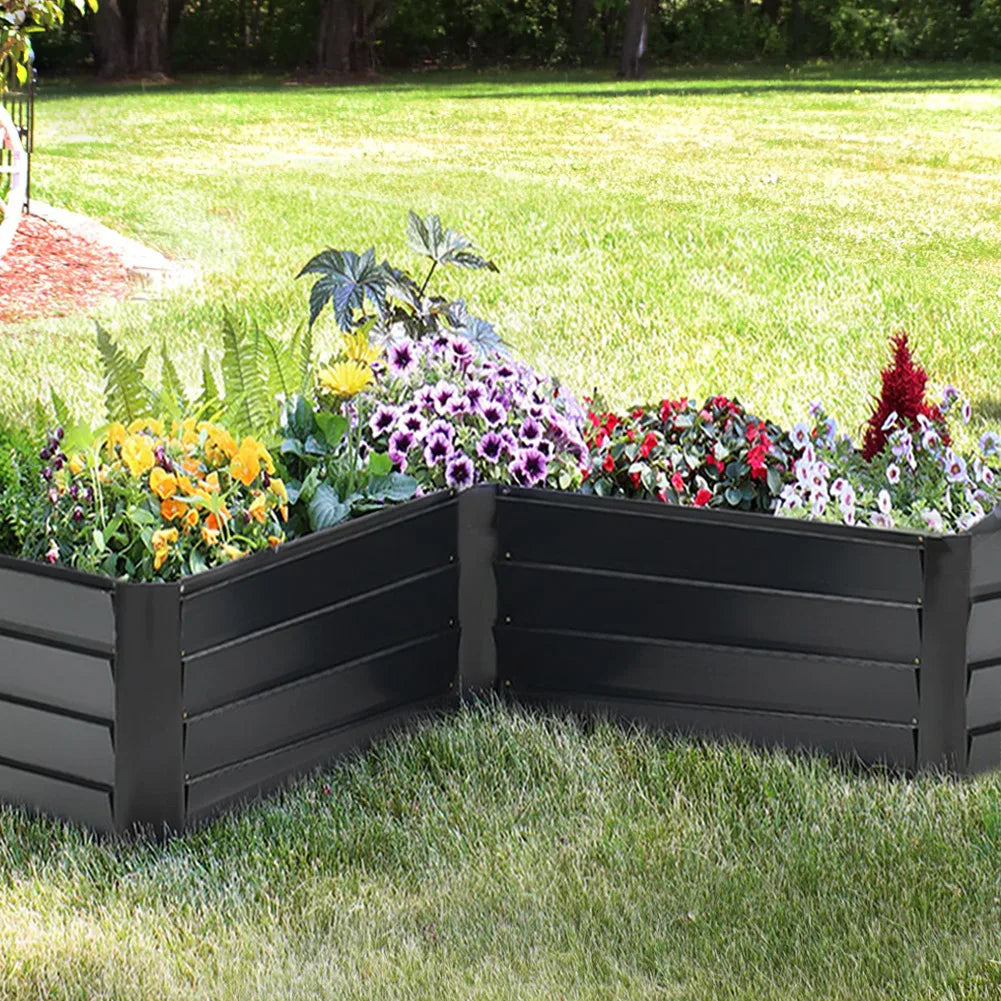 Charcoal black L-shaped metal raised garden bed with layered sides, filled with flowers