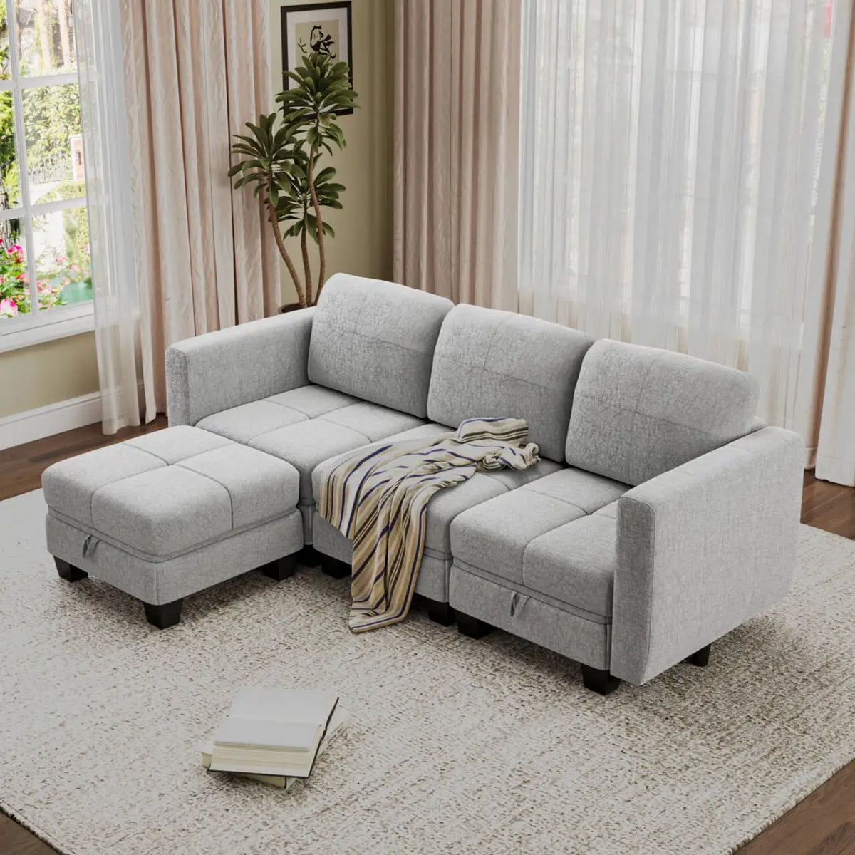 Light gray fabric sectional sofa with chaise ottoman and layered throw blanket