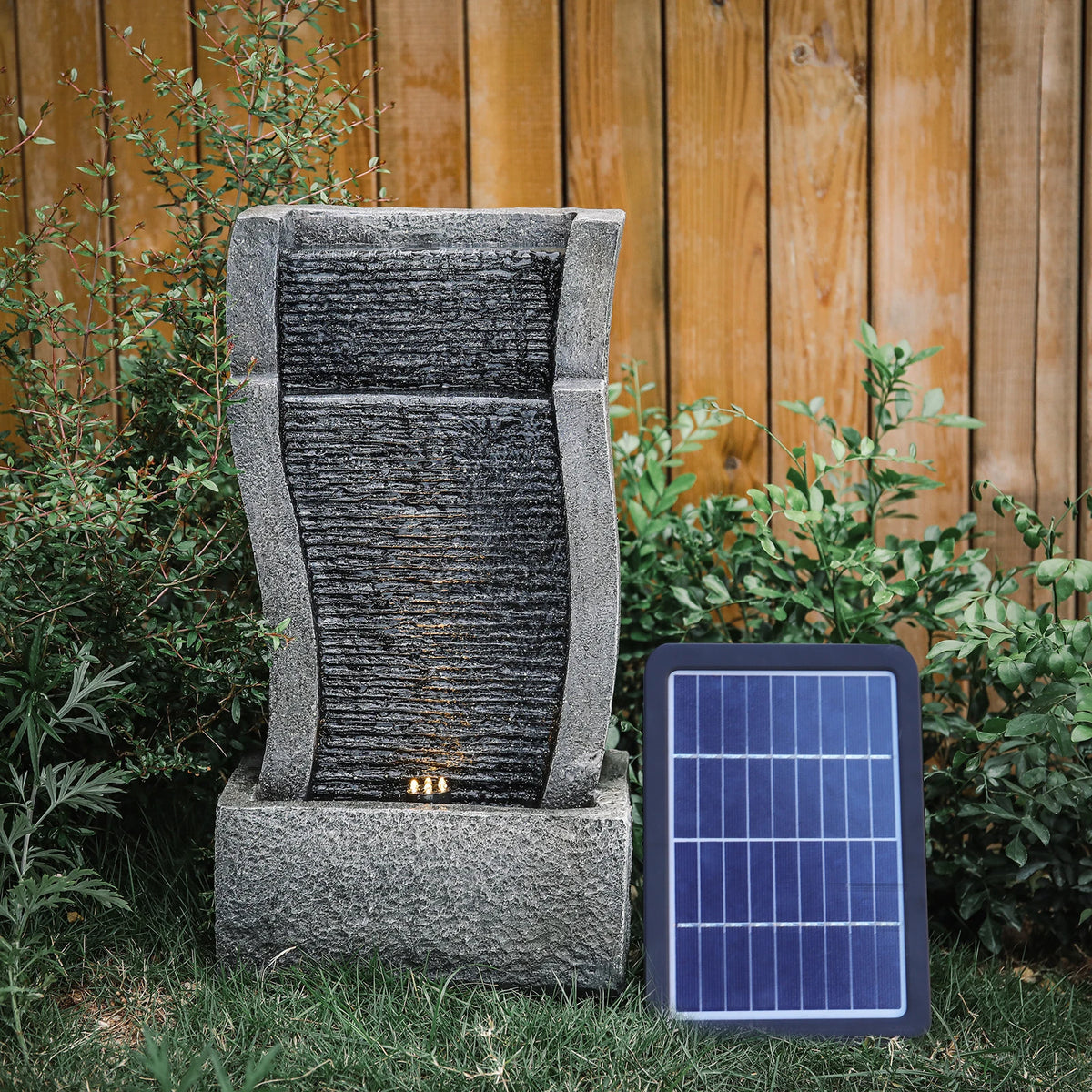 Solar outdoor rockery fountain with textured gray wall, water feature, and solar panel