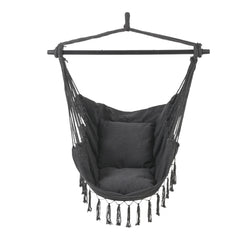 Dark gray canvas hanging swing chair with fringe tassels and spreader bar frame.