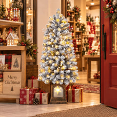 Snow-frosted pre-lit potted Christmas tree with warm white lights and glowing base lantern