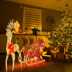Lit reindeer and red sleigh outdoor decoration displayed near Christmas tree and gifts