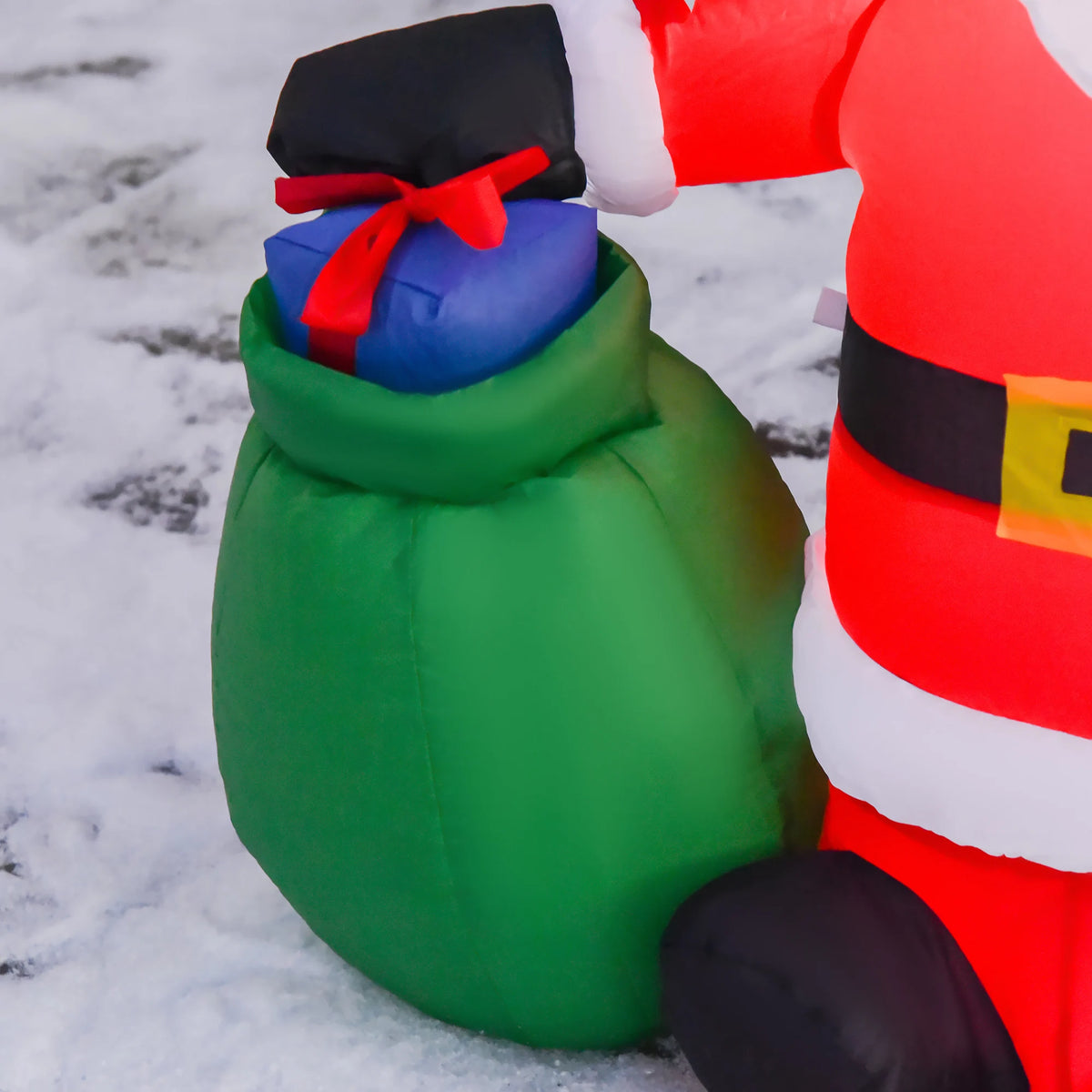 Close-up inflatable Santa with green gift sack and blue-red present, red suit trim
