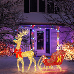 Illuminated golden reindeer with red bow and red sleigh on glowing wire lights