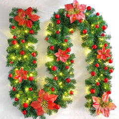 Red LED rattan garland close-up with green foliage, red berries, poinsettias, warm lights