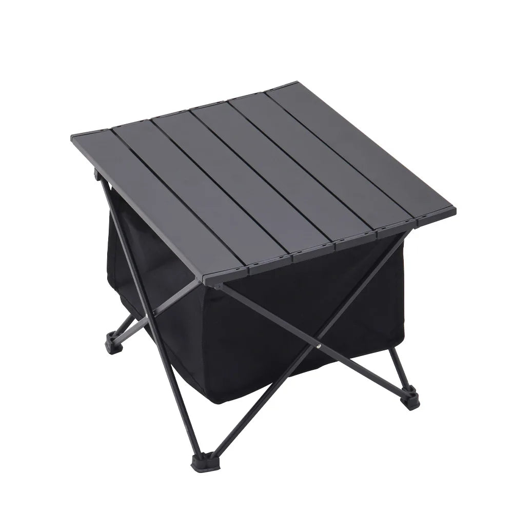 Black folding outdoor table with slatted top and storage bin, angled view