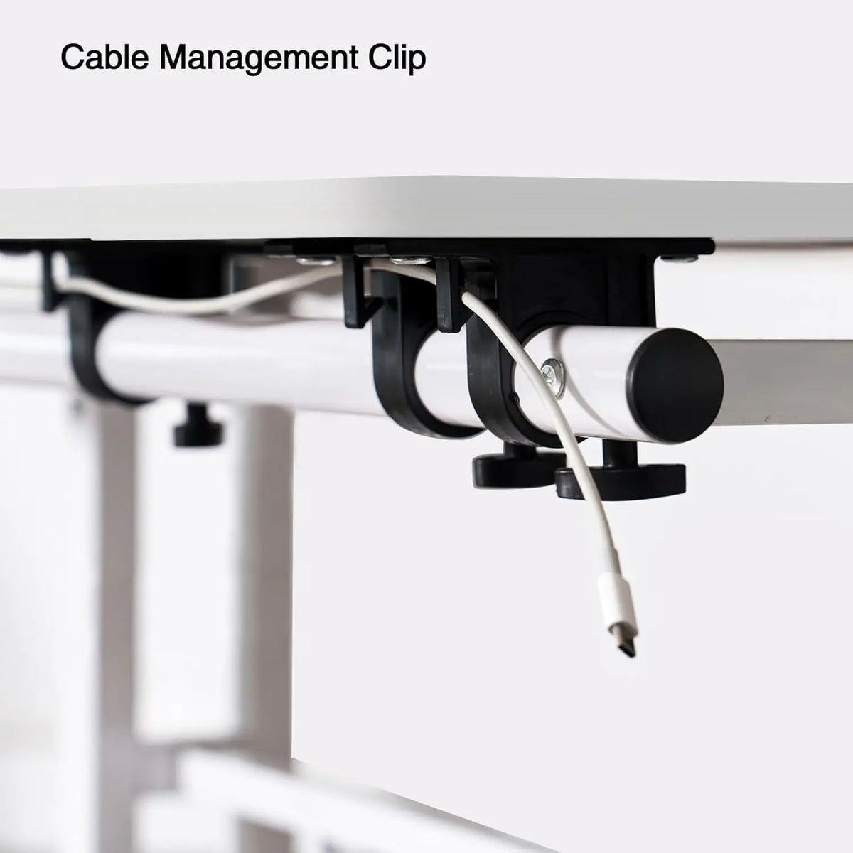 Cable management clip on underside of white tilting standing desk tabletop