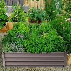 Outdoor raised bed planter with dark gray slatted frame, filled with leafy greens.