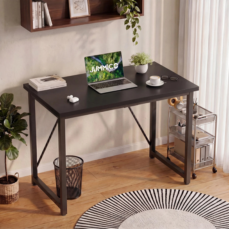 Black computer desk with wide tabletop and angled metal legs for office work