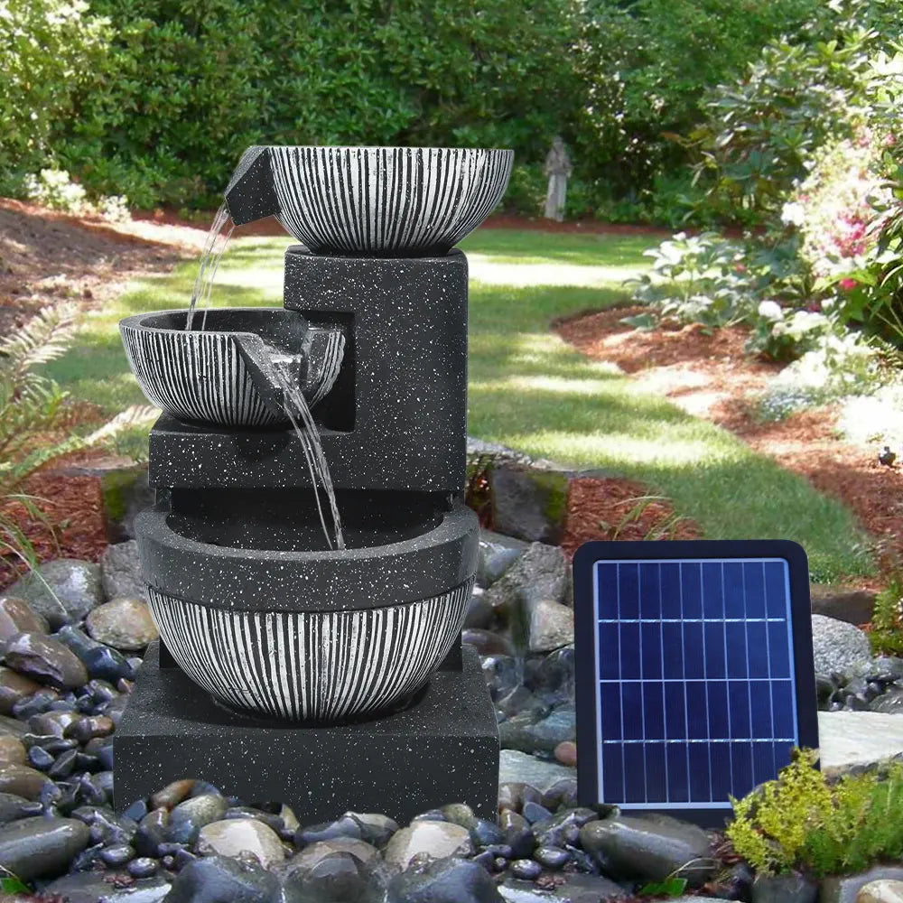 Solar outdoor rockery fountain with flowing water in gray stone basins and solar panel