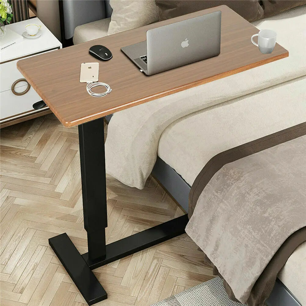 Adjustable bedside laptop desk with wood-look top, black base, and tabletop accessories