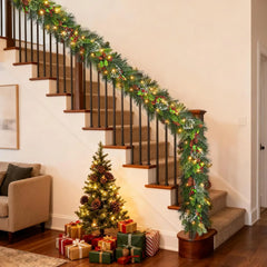 Christmas vine garland with pine greenery and warm lights along stair steps