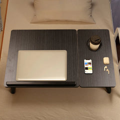 Foldable laptop bed tray with textured dark top, cup holder, and phone stand area